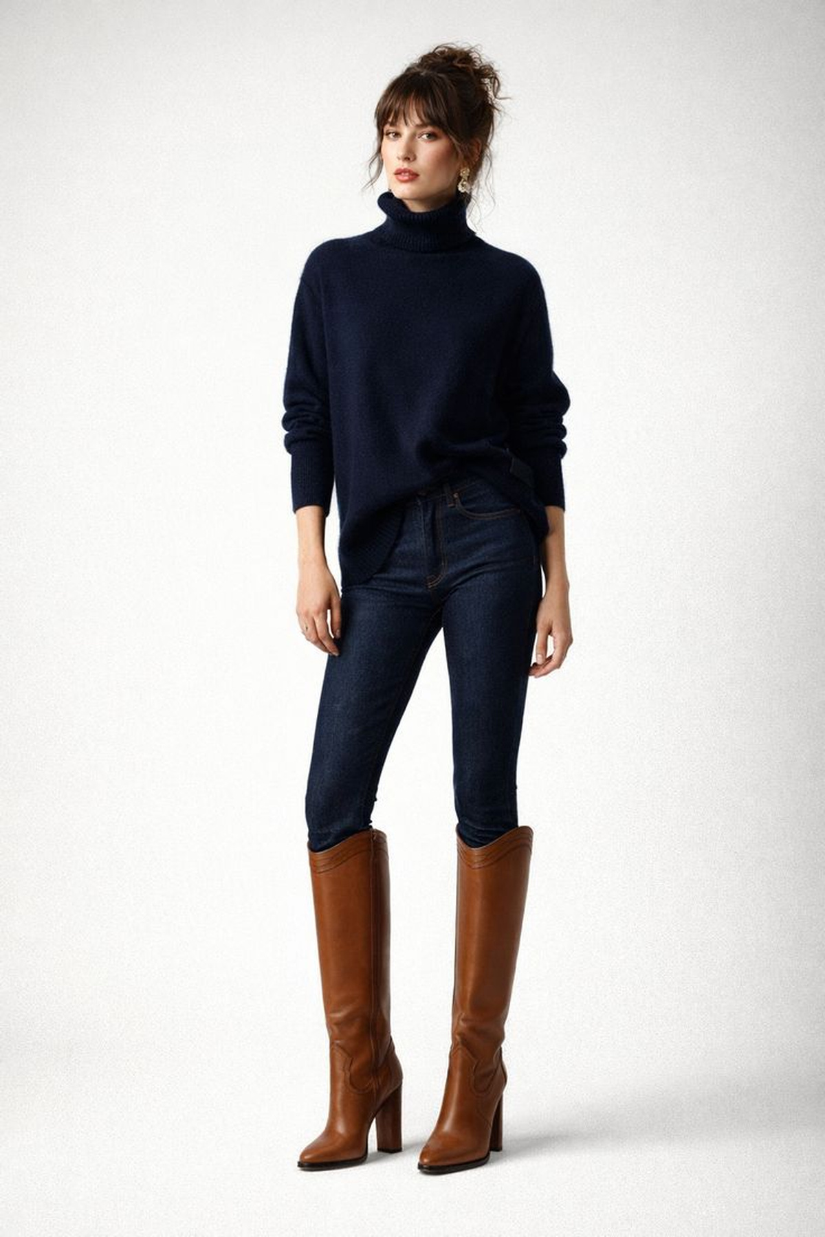 Navy turtleneck styled with dark straight jeans and tall cognac boots.